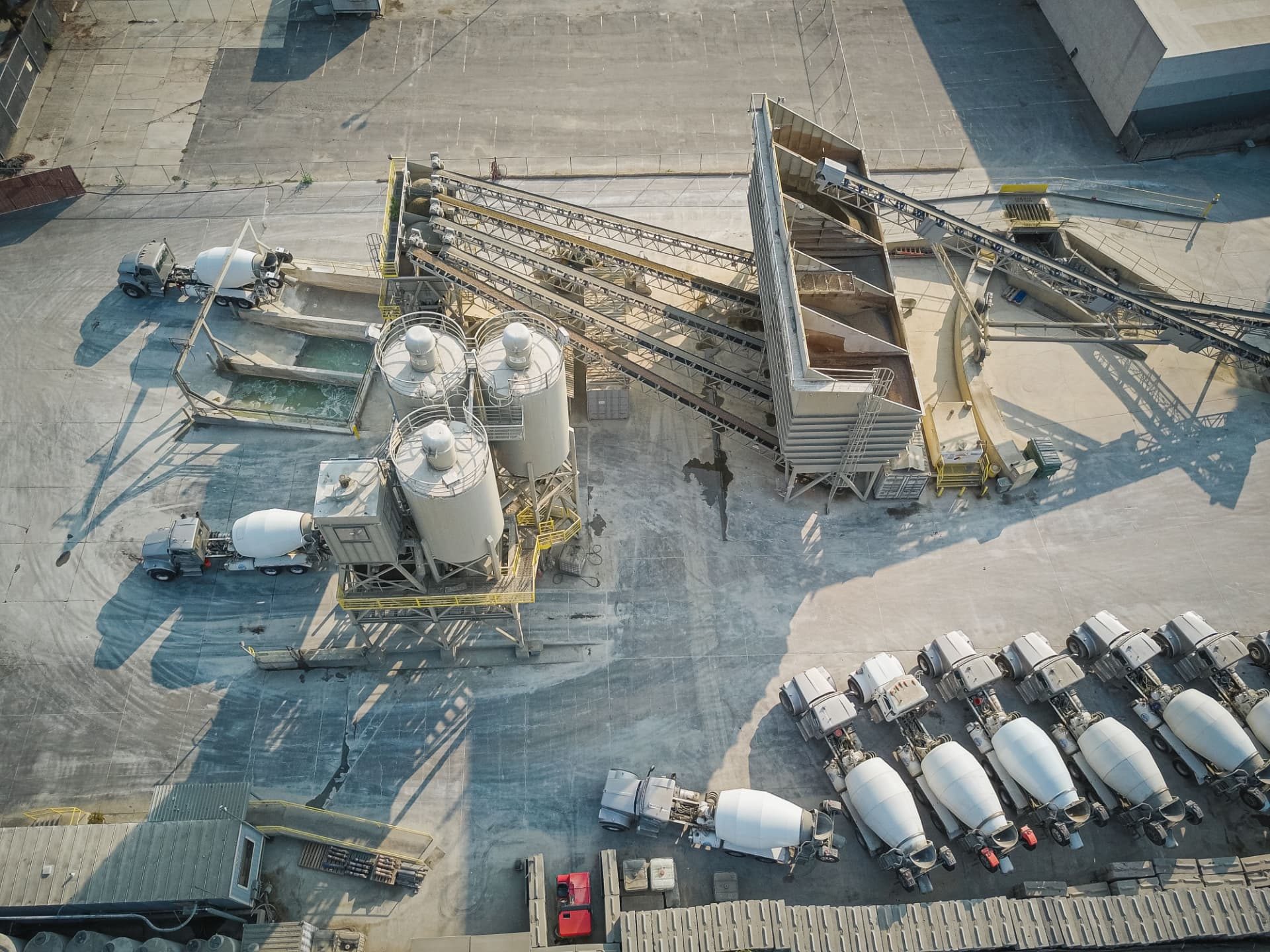 Aerial view of an industrial processing facility with conveyors, silos and material-handling equipment
