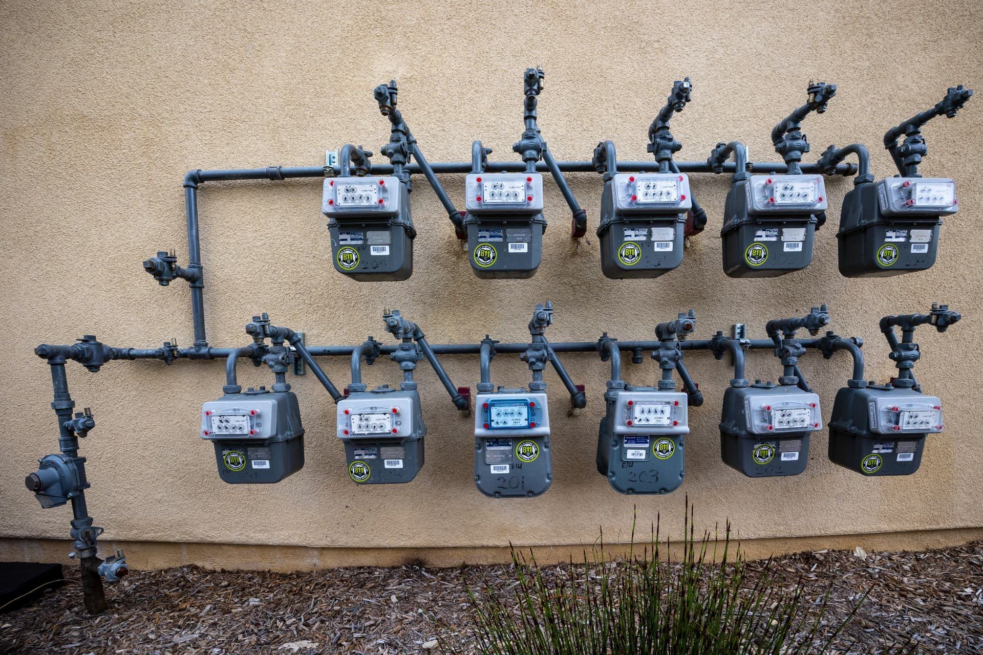 Utility gas meters and distribution pipework installed on an external wall