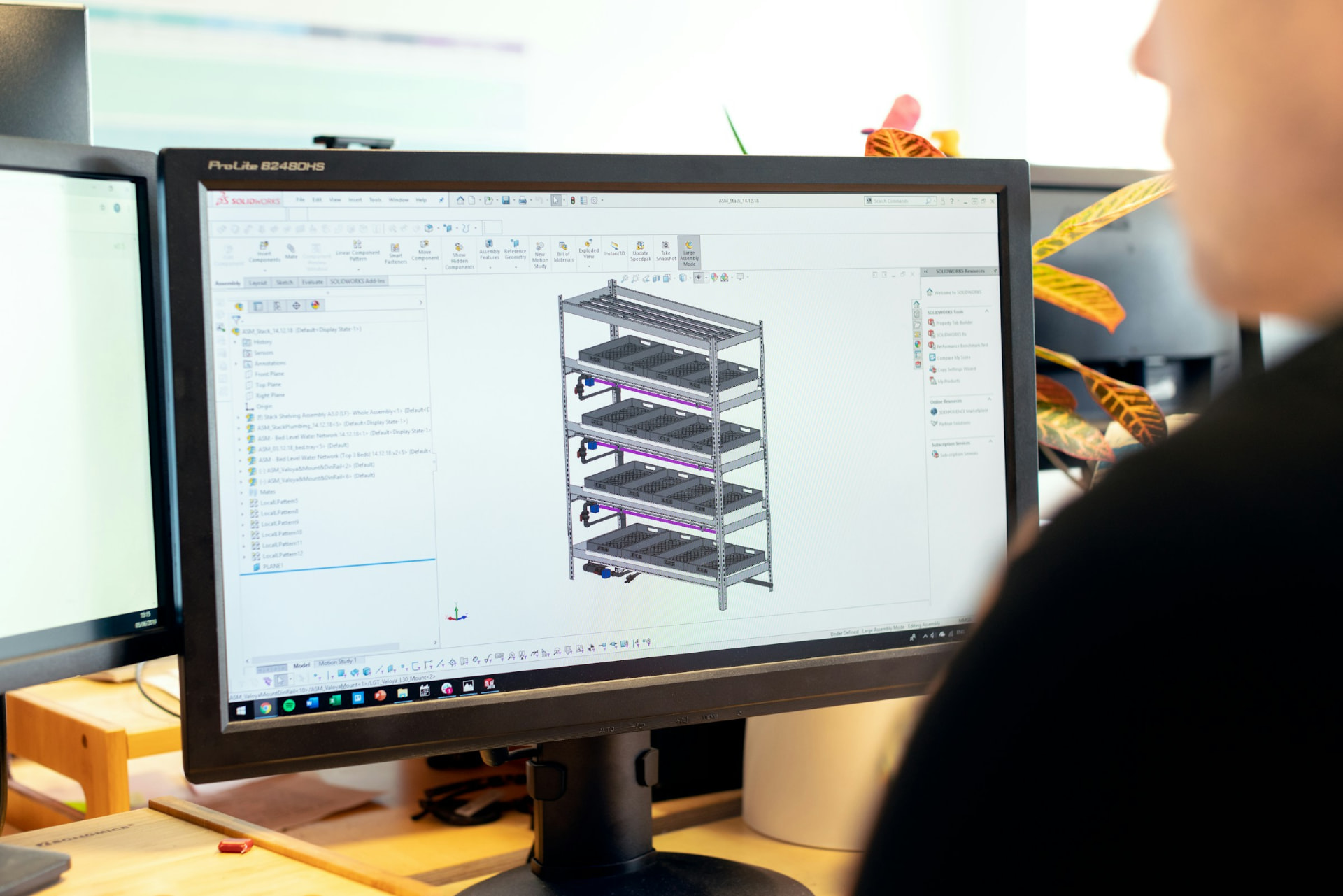 Engineer developing a 3D CAD model of a structural frame assembly on a design workstation